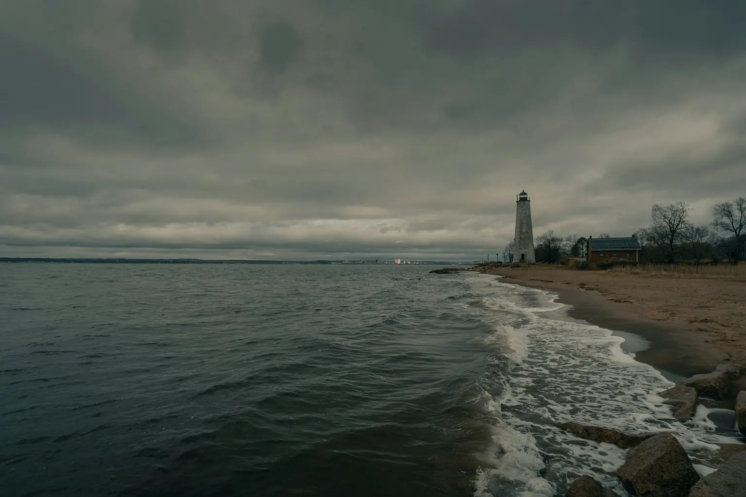 The shore at Lighthouse Point in New Haven, Connecticut, on a gray afternoon.